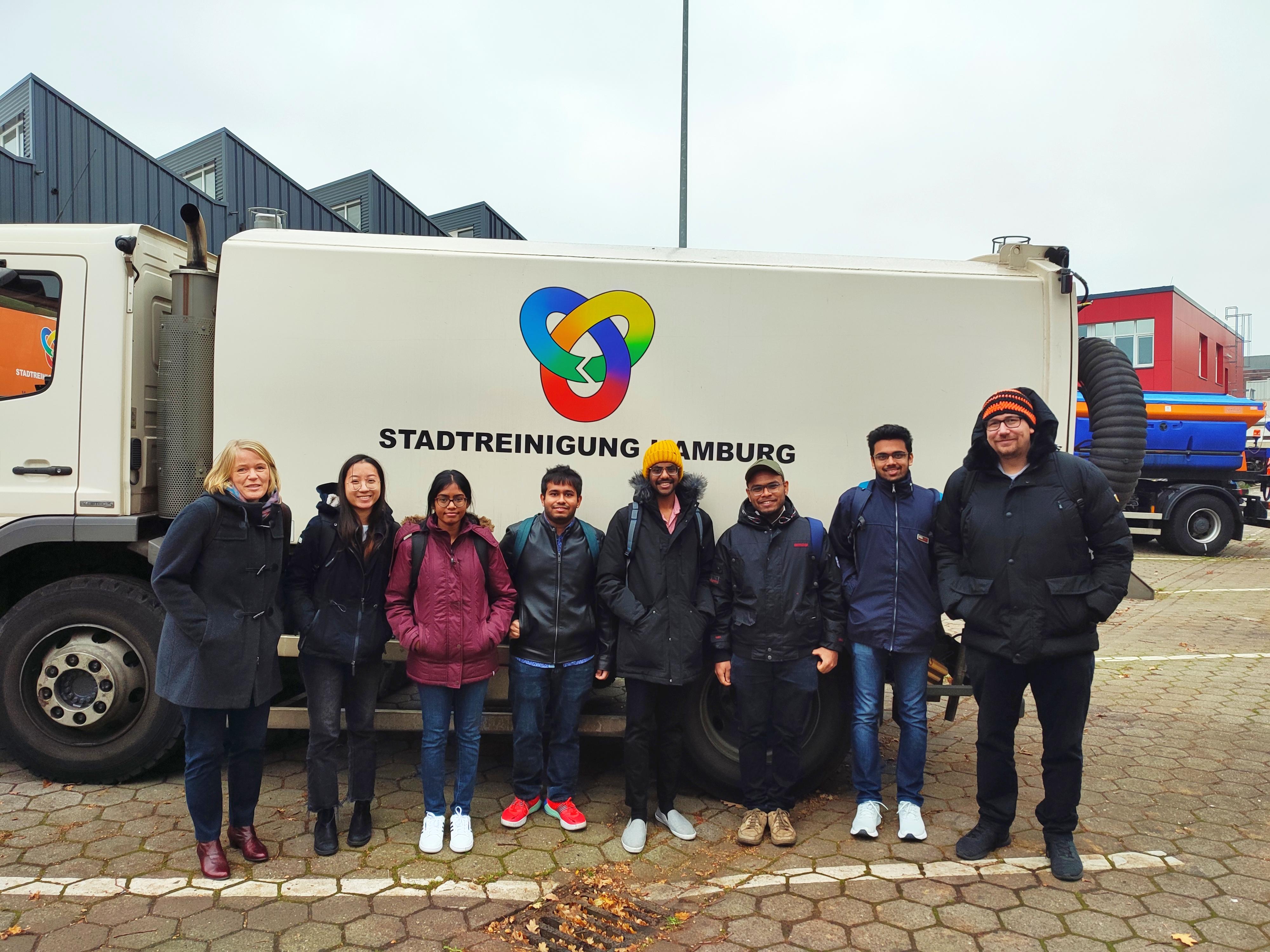 Studierende mit Laster im Hintergrund